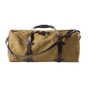 A duffel bag in desert tan colour with leather handles and leather shoulder strap.